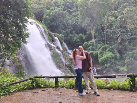A couple close together with the waterfall behind - lifeonwheel.com
