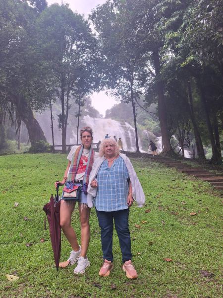 Grandmother and granddaughter on the lawn by the falls - lifeonwheel.com