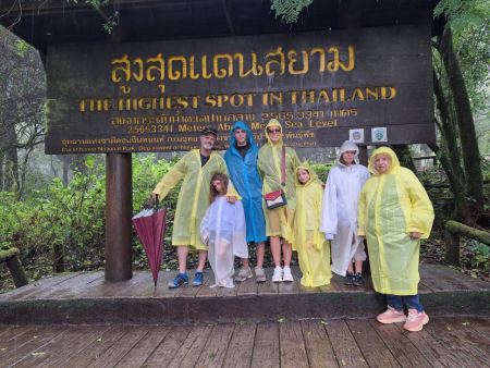 The whole family in ponchos at the highest point sign - lifeonwheel.com