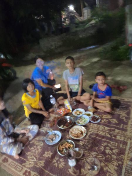 A family picnic on a mat under the trees at night - lifeonwheel.com