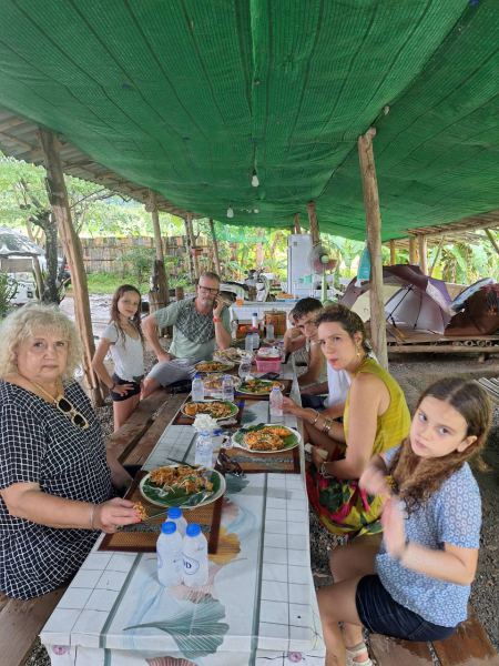 A large group lunch under the green shade cloth - lifeonwheel.com