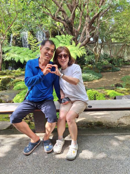 A couple making a heart sign by the garden pond - lifeonwheel.com