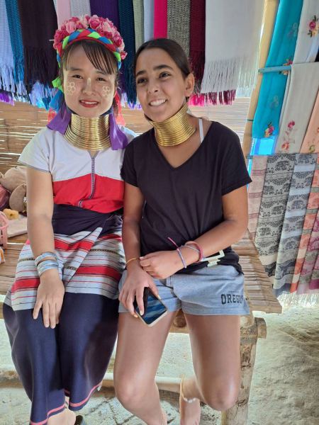 A young guest wearing neck rings beside a Karen girl - lifeonwheel.com