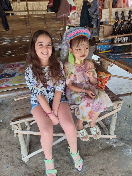 A young guest sitting with a Karen child in the village - lifeonwheel.com