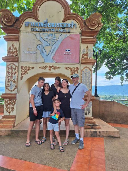 A family at the Golden Triangle arch with the border map - lifeonwheel.com