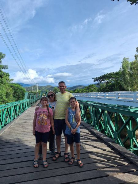 A family on the green metal bridge over the river - lifeonwheel.com