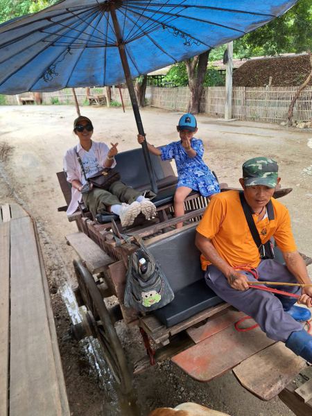 Guests aboard the ox cart under a blue parasol - lifeonwheel.com