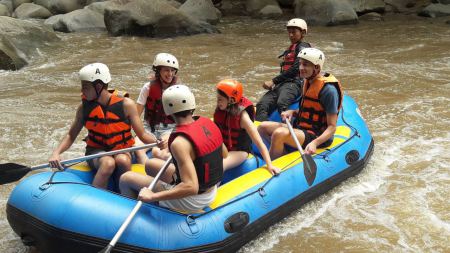 Paddling hard on the inflatable raft through white water - lifeonwheel.com