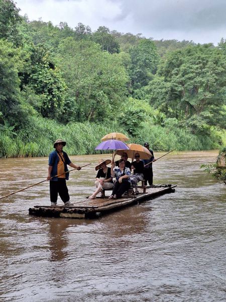 Umbrellas up on the bamboo raft in the rain - lifeonwheel.com