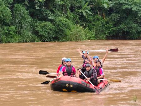 Cheering with paddles high on the muddy river - lifeonwheel.com