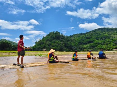 Poling the bamboo raft across the calm reservoir - lifeonwheel.com
