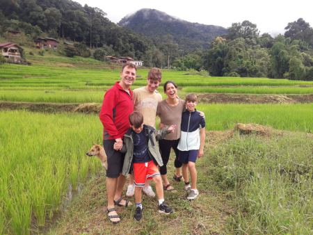 A family with a puppy beside the green rice paddy - lifeonwheel.com