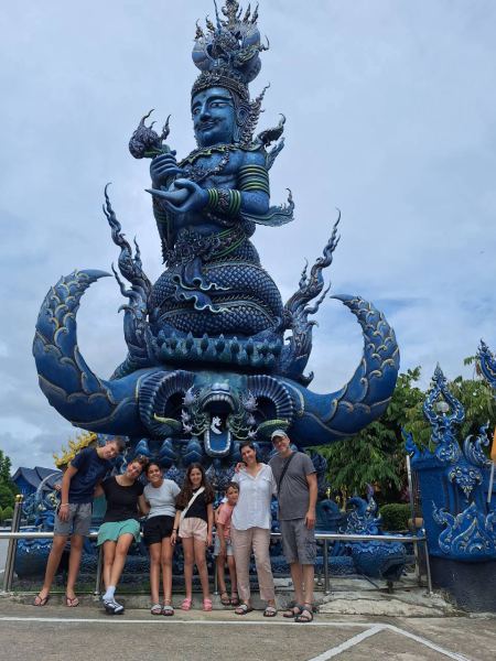 A family beneath the towering blue guardian - lifeonwheel.com