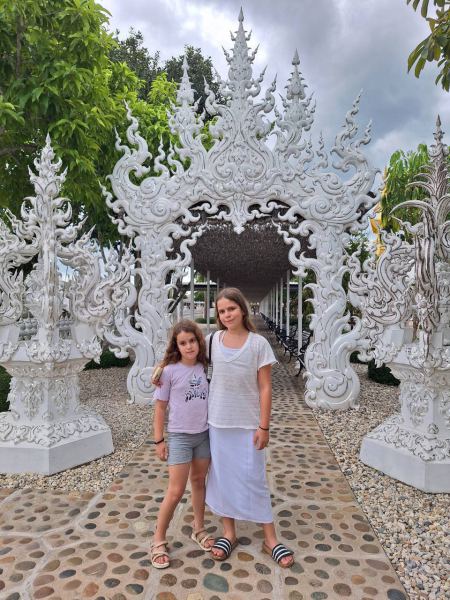 Guests at the ornate white gateway of the White Temple - lifeonwheel.com