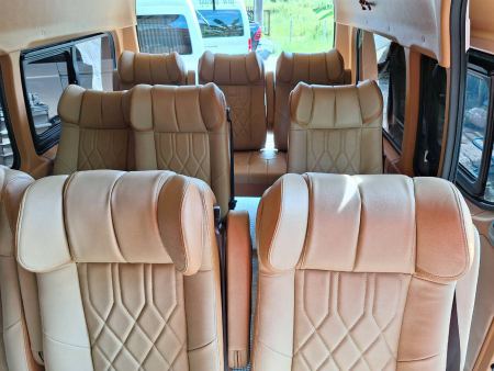 A full row of tan leather seats inside the van - lifeonwheel.com