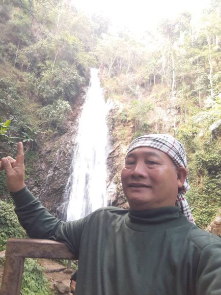 Our guide pointing out the tall forest waterfall - lifeonwheel.com