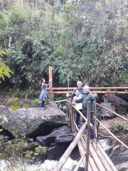 A family crossing the bamboo bridge over the stream - lifeonwheel.com