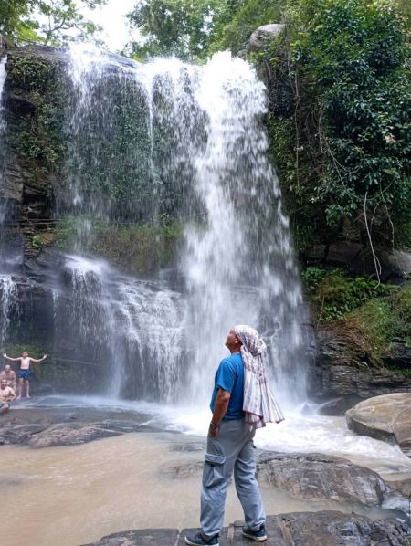 Our guide looking up at the tall cascading falls - lifeonwheel.com